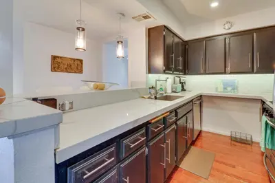 a kitchen with brown cabinets and a white counter top at Granada Hills Condo with Community Pool and Workspace in Los Angeles