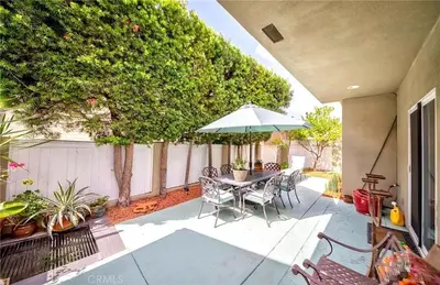 a patio with a table and chairs and an umbrella at Redondo Beach Suite, 2 BR 1st floor Surf Gym workspace in Redondo Beach