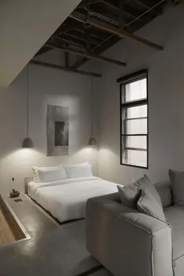 a bedroom with a white bed and a couch at kodō hotel - Heart of LA Arts District in Los Angeles