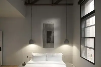 a bedroom with a white bed and two lights at kodō hotel - Heart of LA Arts District in Los Angeles