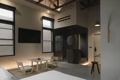 a room with a table and chairs and a tv at kodō hotel - Heart of LA Arts District in Los Angeles