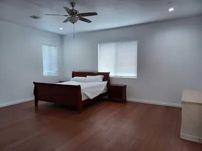 a bedroom with a bed and a ceiling fan at Achievers in Palmdale