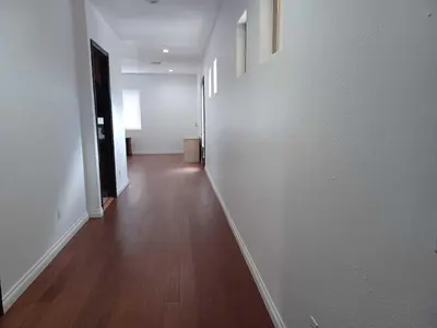 an empty hallway with white walls and a wooden floor at Achievers in Palmdale