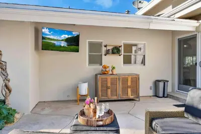a living room with a tv on the wall at Modern Family Farmhouse with Pool, Jacuzzi, Putting Green, Treehouse, Bocce and more in Thousand Oaks