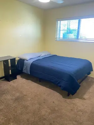 a bedroom with a blue bed and a desk at Lovely Home at Westminster in Westminster
