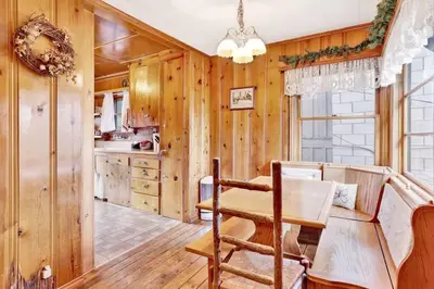 a dining room with a table and a kitchen at Temple Lake Views Walk To Marina & Village Cabin in Big Bear Lake