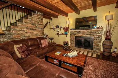 a living room with a leather couch and a fireplace at How Sweet It Is~ Downtown Village Retreat Cabin~ Walk to Marinas and Shopping in Big Bear Lake