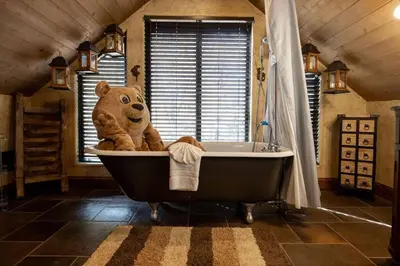 a teddy bear sitting in a tub in a bathroom at How Sweet It Is~ Downtown Village Retreat Cabin~ Walk to Marinas and Shopping in Big Bear Lake