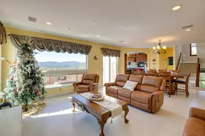 a living room with a christmas tree in the corner at Lake Arrowhead Home with 3 Decks and Stunning Views! in Lake Arrowhead