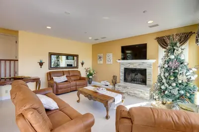 a living room with a christmas tree in front of a fireplace at Lake Arrowhead Home with 3 Decks and Stunning Views! in Lake Arrowhead
