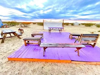 a picnic table and benches on the beach at Beysicair Tents & Campground in California City