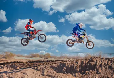 two people on dirt bikes jumping in the air at Beysicair Tents & Campground in California City