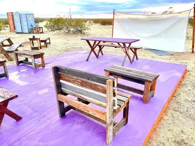 a group of picnic tables and benches on a blanket at Beysicair Tents & Campground in California City