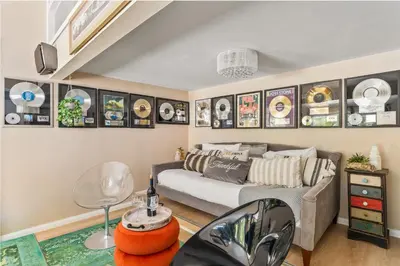 a living room with a couch and posters on the wall at The Malibu Retreat Guest House - Salt Water Pool & Jacuzzi, Nature Oasis in Calabasas