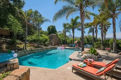 a swimming pool with palm trees and a resort at The Malibu Retreat Guest House - Salt Water Pool & Jacuzzi, Nature Oasis in Calabasas