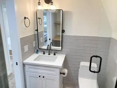 a bathroom with a sink and a mirror and a toilet at Oceanfront Penthouse On Sand - Epic Views/Sunsets! in Huntington Beach