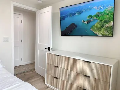 a bedroom with a flat screen tv on a wall at Oceanfront Penthouse On Sand - Epic Views/Sunsets! in Huntington Beach