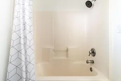 a white bathroom with a tub and a shower at Big Bear Spa Suites in Big Bear Lake