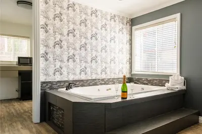 a bathroom with a bath tub with a bottle of champagne at Big Bear Spa Suites in Big Bear Lake