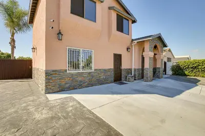 a house with a gate and a palm tree at Hidden Gem in Hawthorne about 3 Mi to SoFi Stadium in Hawthorne