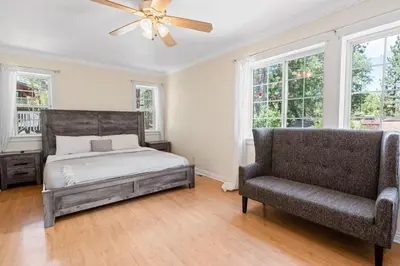a bedroom with a bed and a couch and windows at Paramount Paradise in Big Bear Lake
