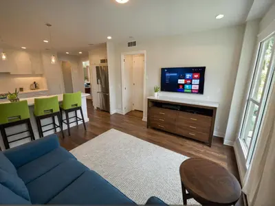 a living room with a blue couch and a kitchen at Glamorous KTown Boutique Residences with Rooftop view in Los Angeles