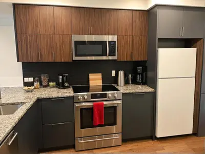 a kitchen with a stainless steel stove and a microwave at Glamorous KTown Boutique Residences with Rooftop view in Los Angeles