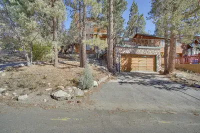 a house with a garage in the woods at Quaint Big Bear Home with Hot Tub 4 Mi to Skiing! in Big Bear City