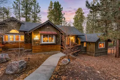 a log home in the woods with a pathway at Big Bear Villa - Walk to Lake ad Village! Hot Tub, Jet Tub and so much more! in Big Bear Lake