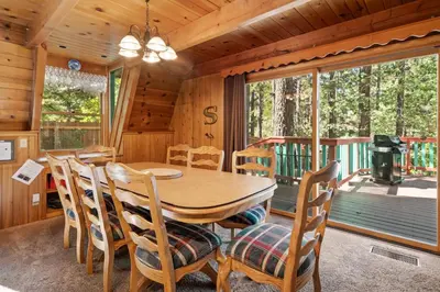 a dining room with a table and chairs in a cabin at Kapers - Located in a beautiful quiet area of Big Bear Lake, walking distance to Snow Summit! in Big Bear Lake
