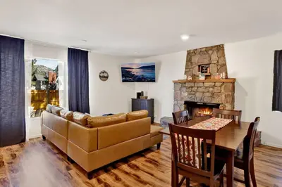 a living room with a couch and a table and a fireplace at The Weekender- Adorable Modern Chic Cottage in Big Bear City