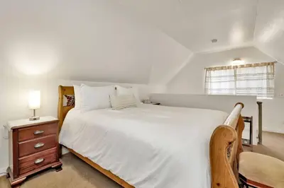 a bedroom with a large white bed and a nightstand at The Weekender- Adorable Modern Chic Cottage in Big Bear City