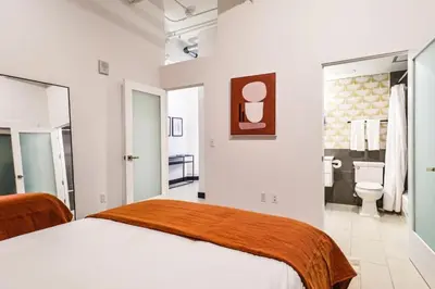 a white bedroom with a bed and a bathroom at Stunning 1 BDR 1 BTH Modern Loft with Pool, Jacuzzi in DTLA! in Los Angeles