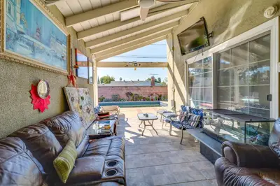 a living room with a leather couch and a table at North Hills Home with Outdoor Entertaining Space in North Hills