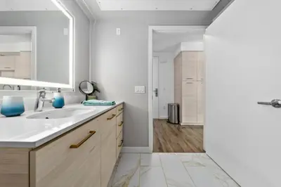 a white bathroom with a sink and a mirror at Amber Drift - Santa Monica 2BR Penthouse Ocean views in Los Angeles