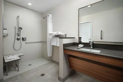 a bathroom with a sink and a shower with a mirror at Fairfield by Marriott Inn & Suites Barstow in Barstow