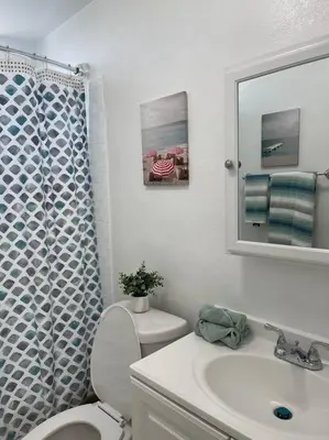 a bathroom with a toilet and a sink and a mirror at Spacious Studio close to LAX and close to beaches! in Gardena