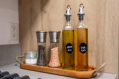 three bottles of oil sitting on a wooden shelf at Cozy Huge LOFT for Live and Work in Los Angeles