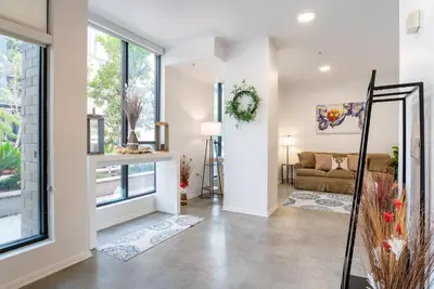 a living room with a couch and large windows at Cozy Huge LOFT for Live and Work in Los Angeles