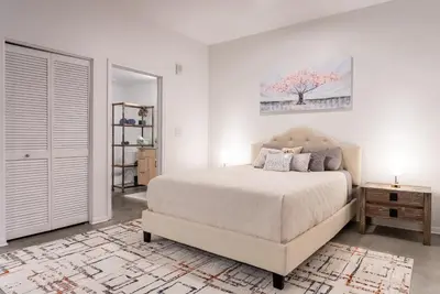 a bedroom with a bed and a tree painting on the wall at Cozy Huge LOFT for Live and Work in Los Angeles