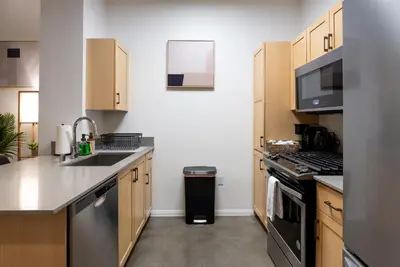 a kitchen with stainless steel appliances and wooden cabinets at Huge luxury loft for enjoying in Los Angeles