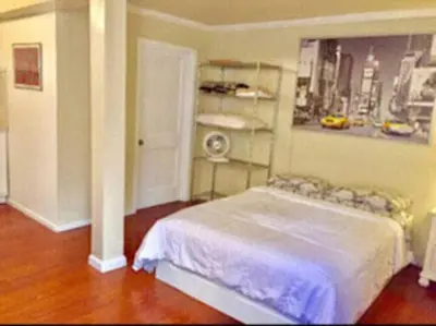 a bedroom with a white bed and a shelf at Echo Park Studio Oasis with Modern Comforts in Los Angeles