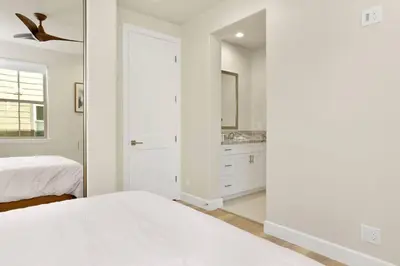 a white bedroom with a bed and a mirror at The Pines Retreat- Impeccable Modern Village Chalet in Big Bear Lake