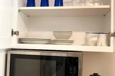 a microwave oven with plates and dishes inside of it at House on The Beach in Los Angeles