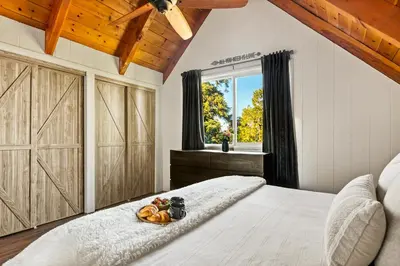 a bedroom with a bed with a tray of fruit on it at Romantic & Family Friendly Chalet In The Woods in Lake Arrowhead