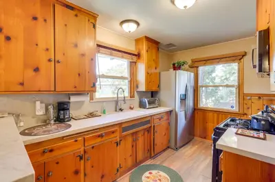 a kitchen with wooden cabinets and a refrigerator at Crestline Cabin Close to Lake Arrowhead and Skiing in Crestline