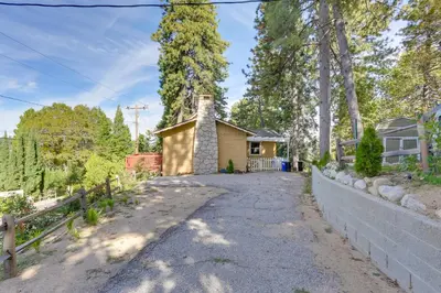 a driveway leading to a yellow house with a fence at Crestline Cabin Close to Lake Arrowhead and Skiing in Crestline