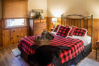 a dog laying on a bed in a bedroom at Crestline Cabin Close to Lake Arrowhead and Skiing in Crestline