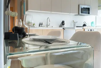 a glass table with two chairs and a wine glass at Stylish Condo By The Beach in Los Angeles