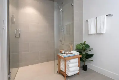 a bathroom with a shower and a table with towels at Stylish Condo By The Beach in Los Angeles